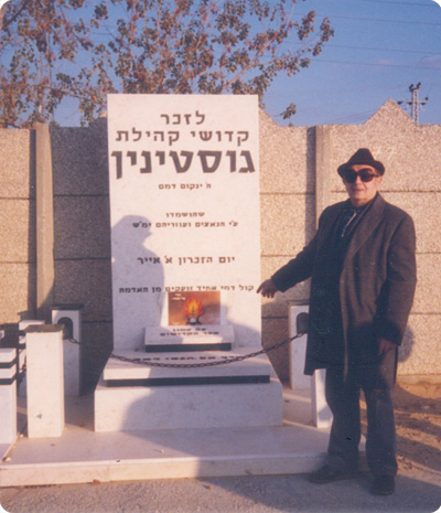 אברהם זנדמן על רקע האנדרטה לקורבנות השואה מגוסטינין בבית הקברות בחולון